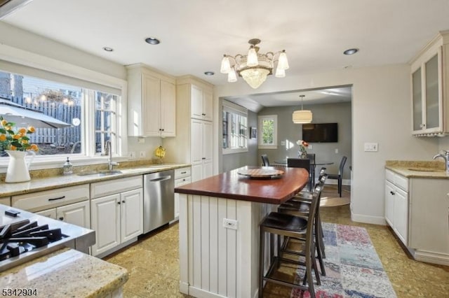 kitchen featuring appliances with stainless steel finishes, a center island, a kitchen bar, and a sink