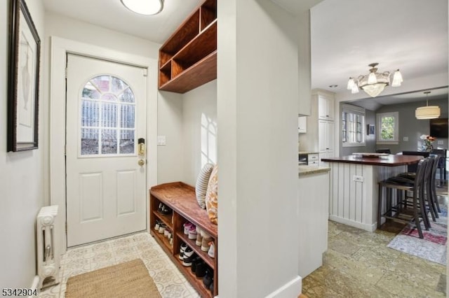 mudroom featuring an inviting chandelier and radiator