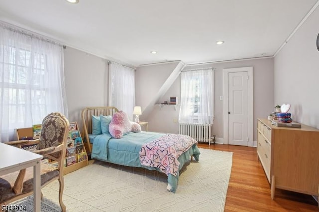 bedroom featuring recessed lighting, light wood-style flooring, and radiator heating unit