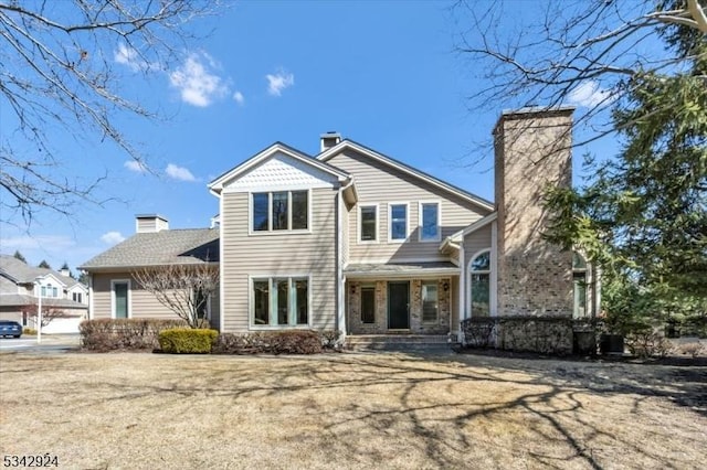 rear view of property featuring a chimney