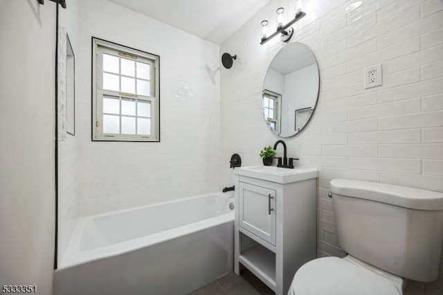 full bath with toilet, tile walls, vanity, and shower / tub combination