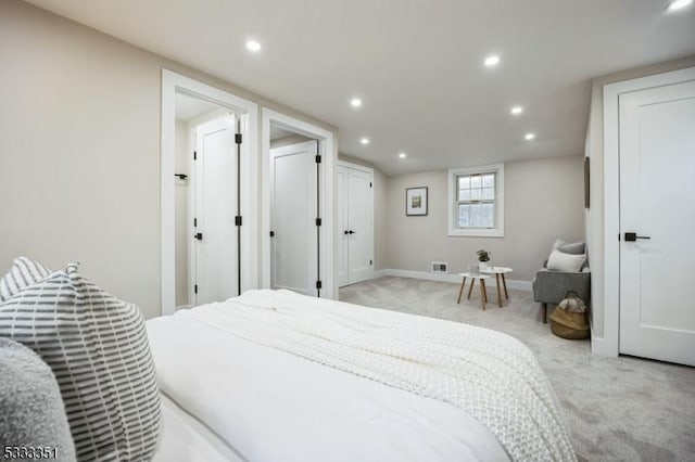 bedroom with visible vents, recessed lighting, light colored carpet, and baseboards