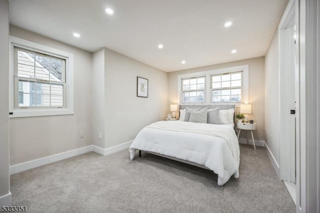 carpeted bedroom featuring recessed lighting, multiple windows, and baseboards