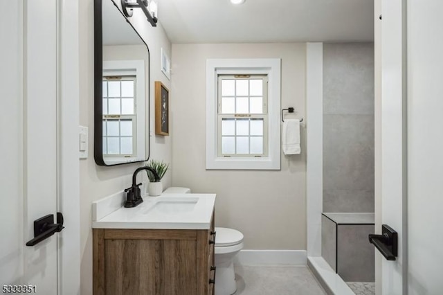 full bath with plenty of natural light, toilet, vanity, and baseboards