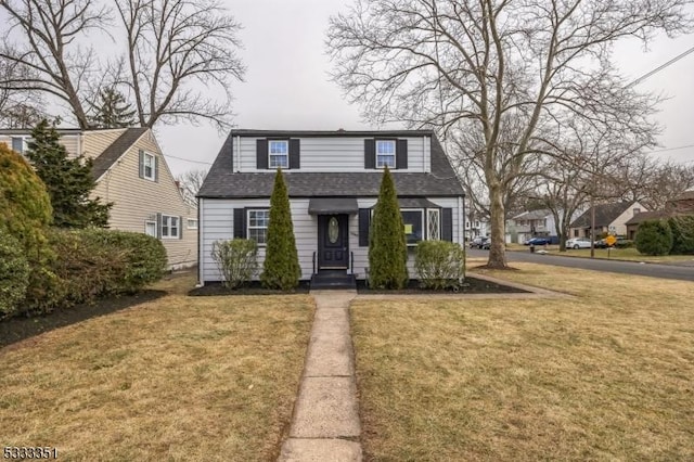 view of front of property featuring a front lawn and a shingled roof