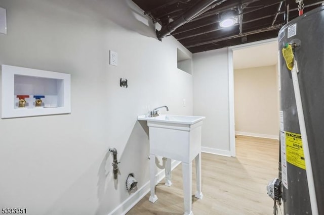 laundry room with baseboards, gas water heater, hookup for a washing machine, wood finished floors, and electric dryer hookup