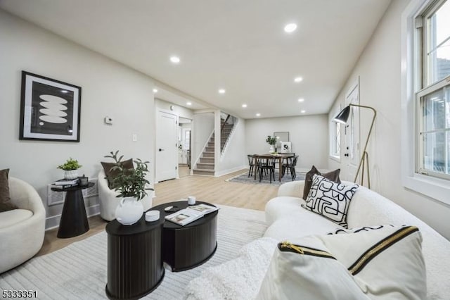 living room with stairway, recessed lighting, light wood-style flooring, and baseboards