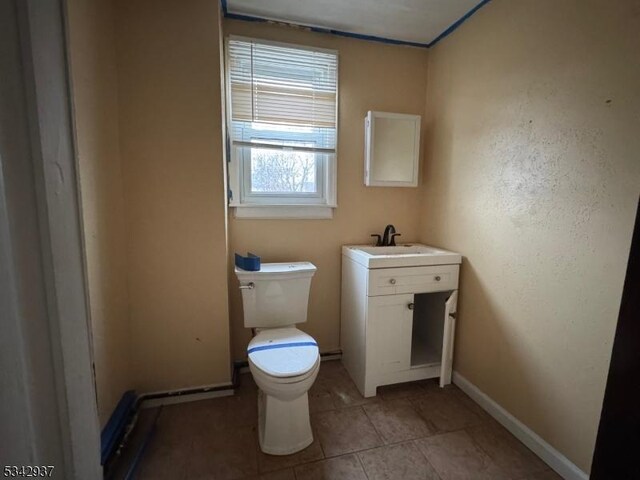 bathroom with vanity, tile patterned floors, toilet, and baseboards