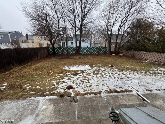 snowy yard featuring a fenced backyard