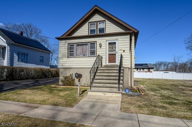 bungalow with a front lawn and fence