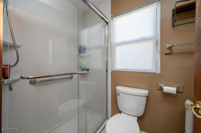 bathroom with an enclosed shower and toilet