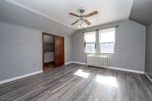 bonus room featuring vaulted ceiling, radiator, baseboards, and wood finished floors