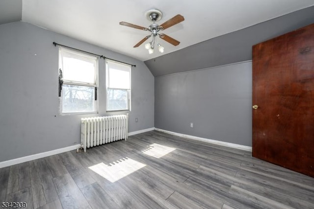 bonus room featuring baseboards, lofted ceiling, wood finished floors, and radiator heating unit