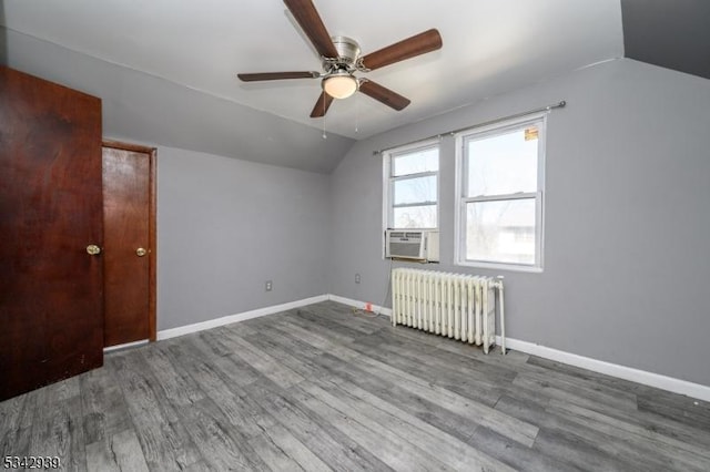 bonus room with lofted ceiling, radiator, wood finished floors, and baseboards