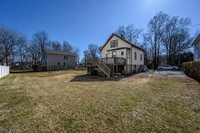 back of property with fence, stairs, a chimney, a deck, and a yard