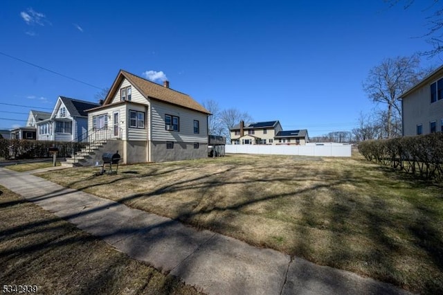 view of side of home featuring a chimney and fence