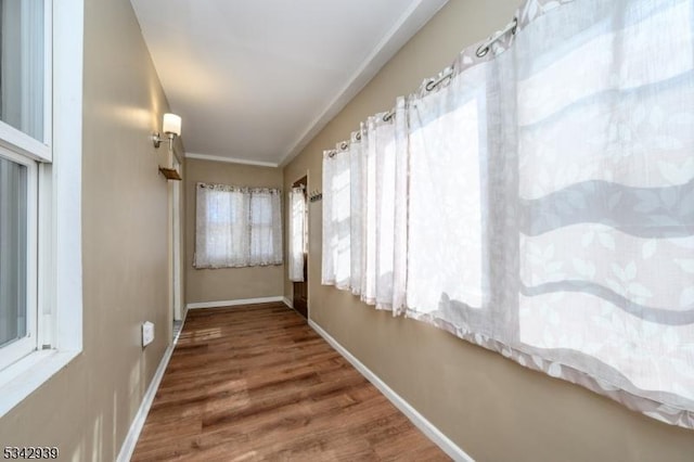 hall featuring baseboards and wood finished floors