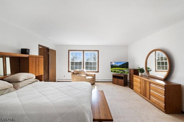 bedroom featuring light colored carpet and a baseboard heating unit