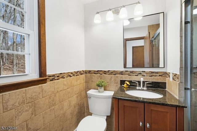 full bathroom with an enclosed shower, plenty of natural light, toilet, and vanity