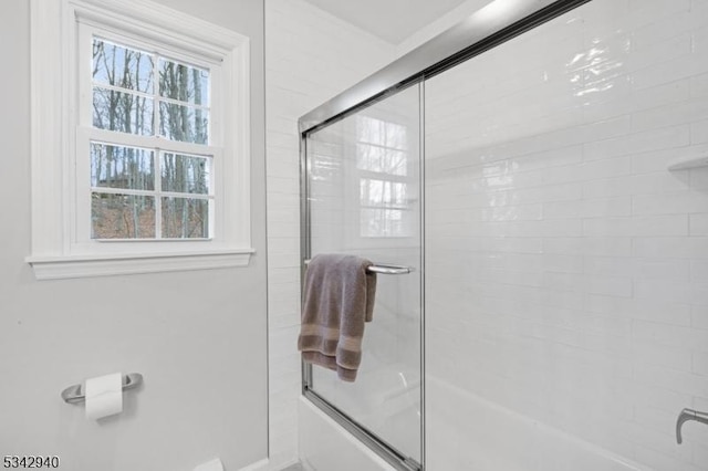 bathroom with baseboards and enclosed tub / shower combo