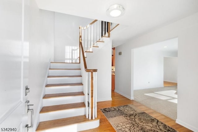 stairs with baseboards and wood finished floors