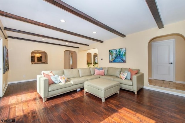 living area featuring beamed ceiling, baseboards, arched walkways, and wood-type flooring