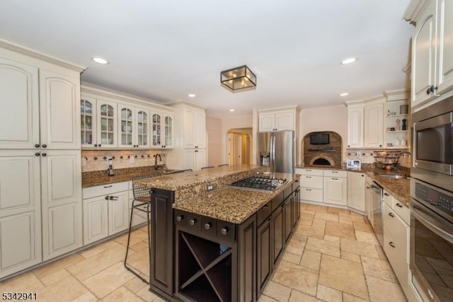 kitchen featuring open shelves, recessed lighting, appliances with stainless steel finishes, and stone tile flooring