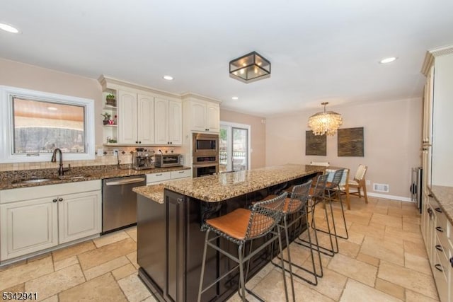 kitchen with stone tile flooring, recessed lighting, stainless steel appliances, and a sink