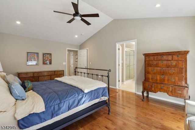 bedroom with a ceiling fan, ensuite bath, wood finished floors, recessed lighting, and vaulted ceiling