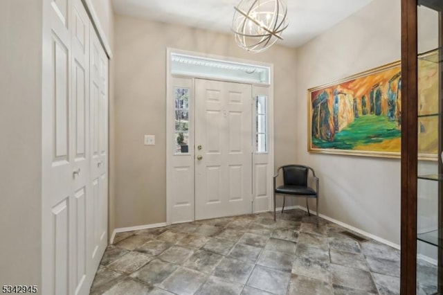 foyer entrance with an inviting chandelier, visible vents, and baseboards