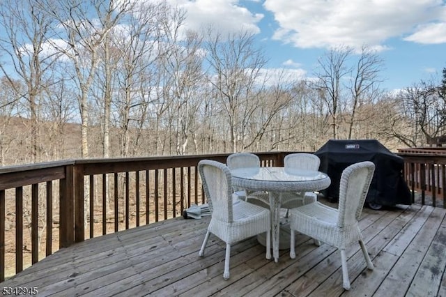 wooden deck featuring outdoor dining space and a grill