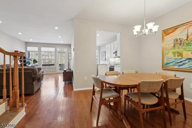 dining room featuring recessed lighting, baseboards, wood-type flooring, and an inviting chandelier