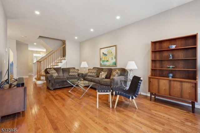 living area with stairway, recessed lighting, light wood-style flooring, and baseboards