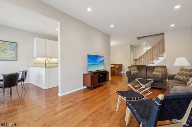 living area with light wood finished floors, stairway, recessed lighting, and baseboards