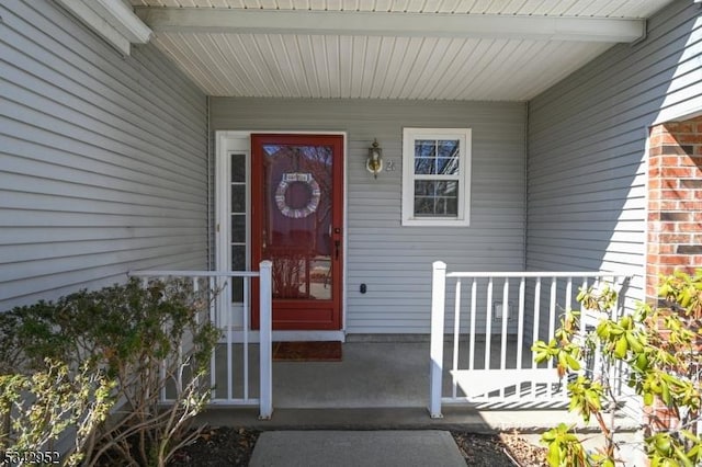 property entrance with brick siding and covered porch