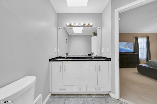 bathroom with a skylight, toilet, visible vents, and a sink