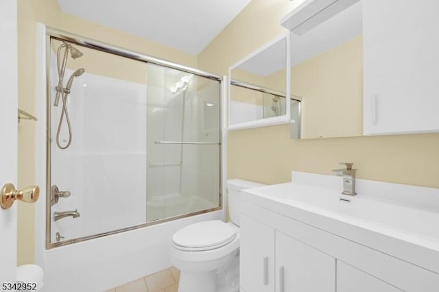 full bathroom with vanity, toilet, tile patterned flooring, and bath / shower combo with glass door