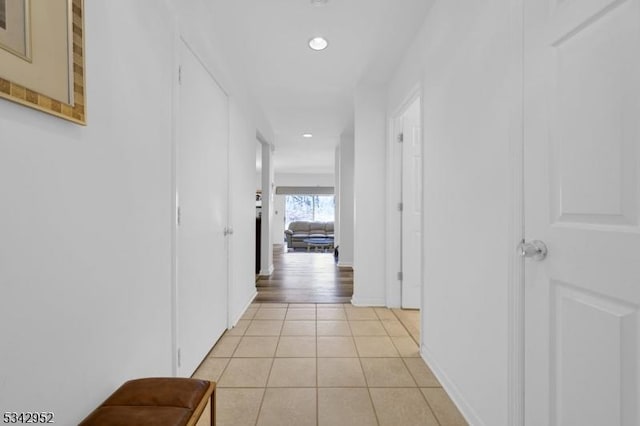 corridor with light tile patterned floors, recessed lighting, and baseboards