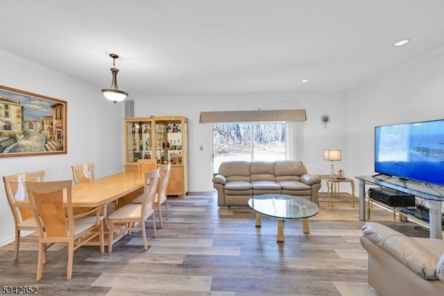 dining room with recessed lighting, crown molding, baseboards, and wood finished floors