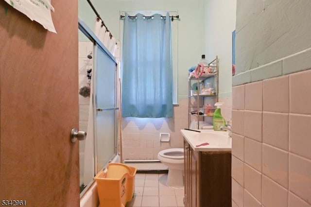 full bathroom featuring vanity, tile patterned flooring, tile walls, toilet, and a shower with door