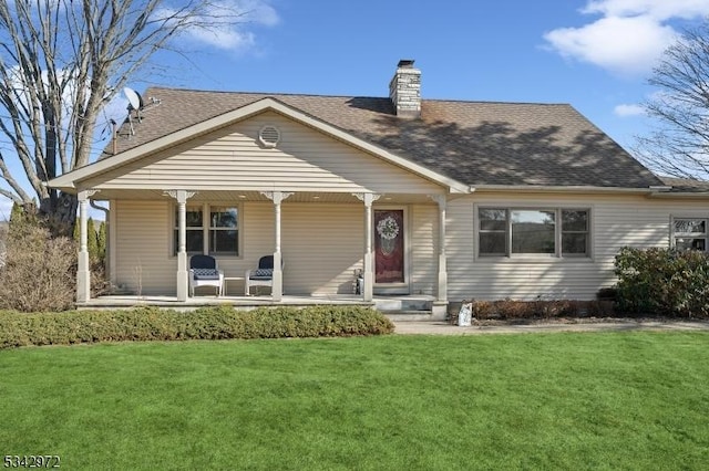 view of front of property with a front lawn, covered porch, roof with shingles, and a chimney