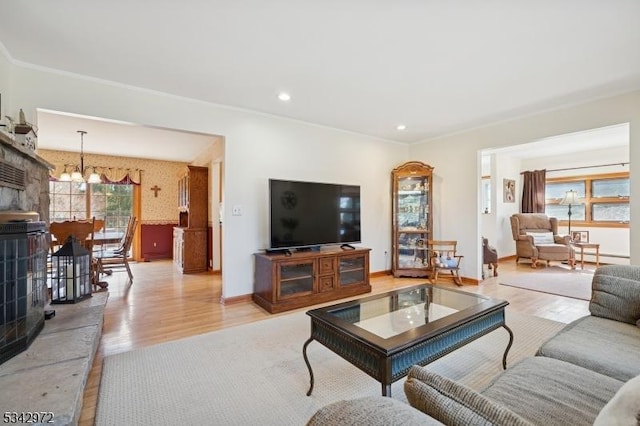 living area with a notable chandelier, recessed lighting, light wood-type flooring, and baseboards