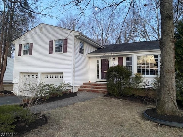 split level home with a garage and entry steps