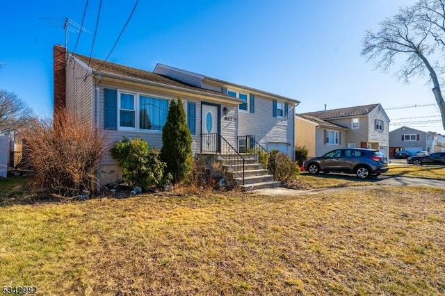 split level home featuring a front lawn and a chimney