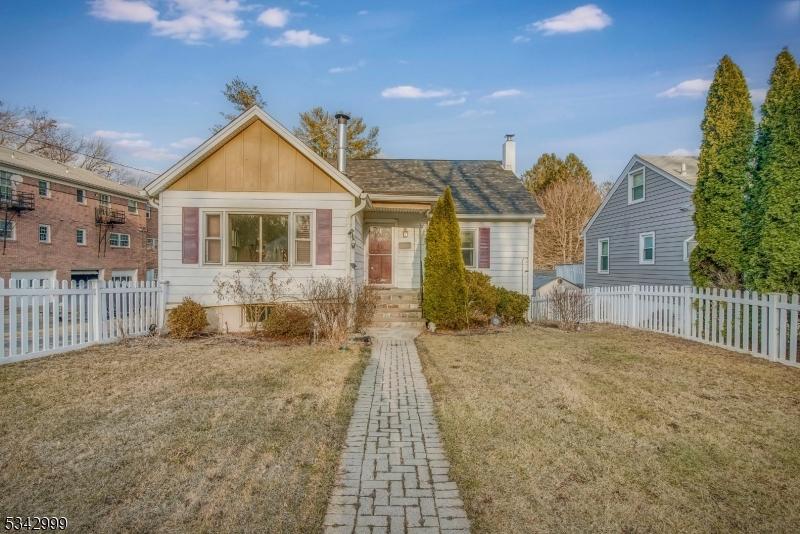 bungalow-style home with a front yard, fence, and board and batten siding