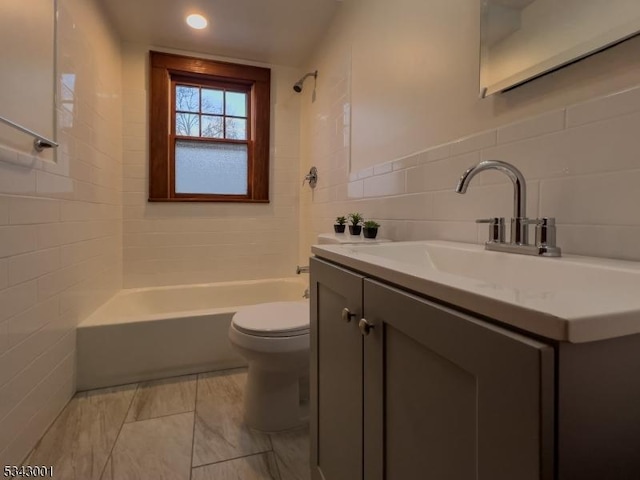 bathroom with vanity, tub / shower combination, recessed lighting, tile walls, and toilet