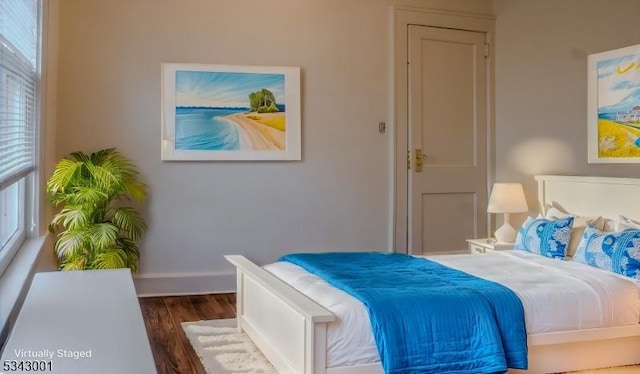 bedroom featuring wood finished floors and baseboards