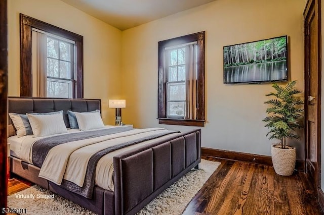 bedroom featuring baseboards and wood finished floors