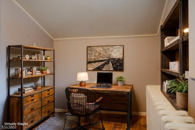 office space with baseboards, radiator heating unit, ornamental molding, vaulted ceiling, and wood finished floors