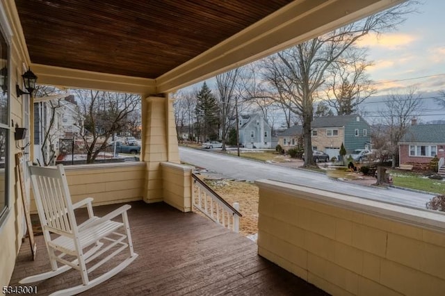 balcony at dusk featuring a residential view and a porch